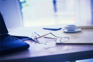photo of pair of reading glasses sitting on work desk