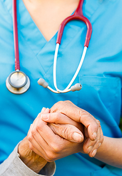an image of a nurse holding a an elderly patients hand